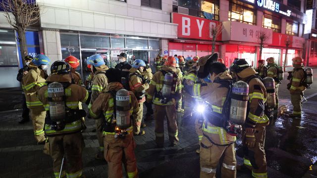Brandmän har samlats utanför den brinnande byggnaden i Seongnam på fredagen. Foto: AP/TT