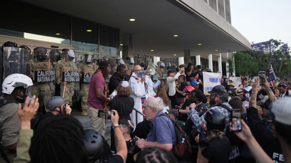 Demonstranter lyssnar på talare medan Kaliforniens nationalgarde håller beredskap under upploppen i Los Angeles. Foto: Eric Thayer/AP/TT