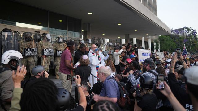 Demonstranter lyssnar på talare medan Kaliforniens nationalgarde håller beredskap under upploppen i Los Angeles. Foto: Eric Thayer/AP/TT