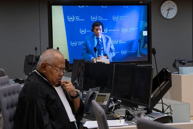 Filippinernas expresident Rodrigo Duterte ses på skärmen i domstolen i Haag. Dutertes advokat Salvador Medialdea till vänster. Peter Dejong/AP/TT