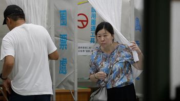 Två väljare vid valurnorna i Taipei under lördagen. Foto: Chiang Ying-ying/AP/TT