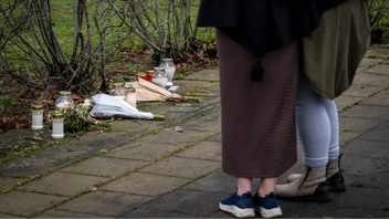 Invånare lämnar blommor och ljus utanför det avspärrade området där en kvinna och ett tioårigt barn hittades döda i ett misstänkt dubbelmord. Foto: Johan Nilsson/TT