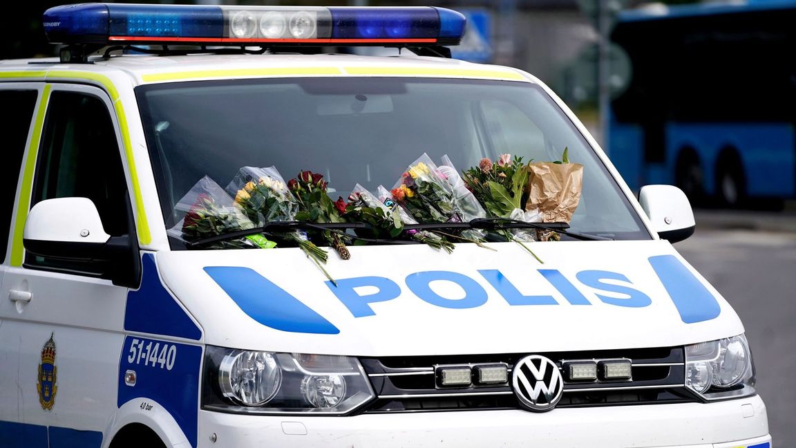 Blommor på en polisbil i Biskopsgården den 1 juli efter att polisen Adreas Danman skjutits ihjäl den 30 juni. Foto: Björn Larsson Rosvall/TT.