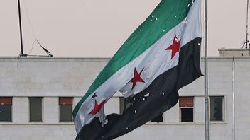 Skadad syrisk flagga efter israeliskt luftangrepp mot ladets försvarsministerium. Bild: AP Photo/Ghaith Alsayed