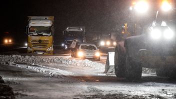Hjullastare och bärgare på plats för att få loss bilar och lastbilar som sitter fast vid Ekerödsrasten på E22. Foto: JOHAN NILSSON/TT