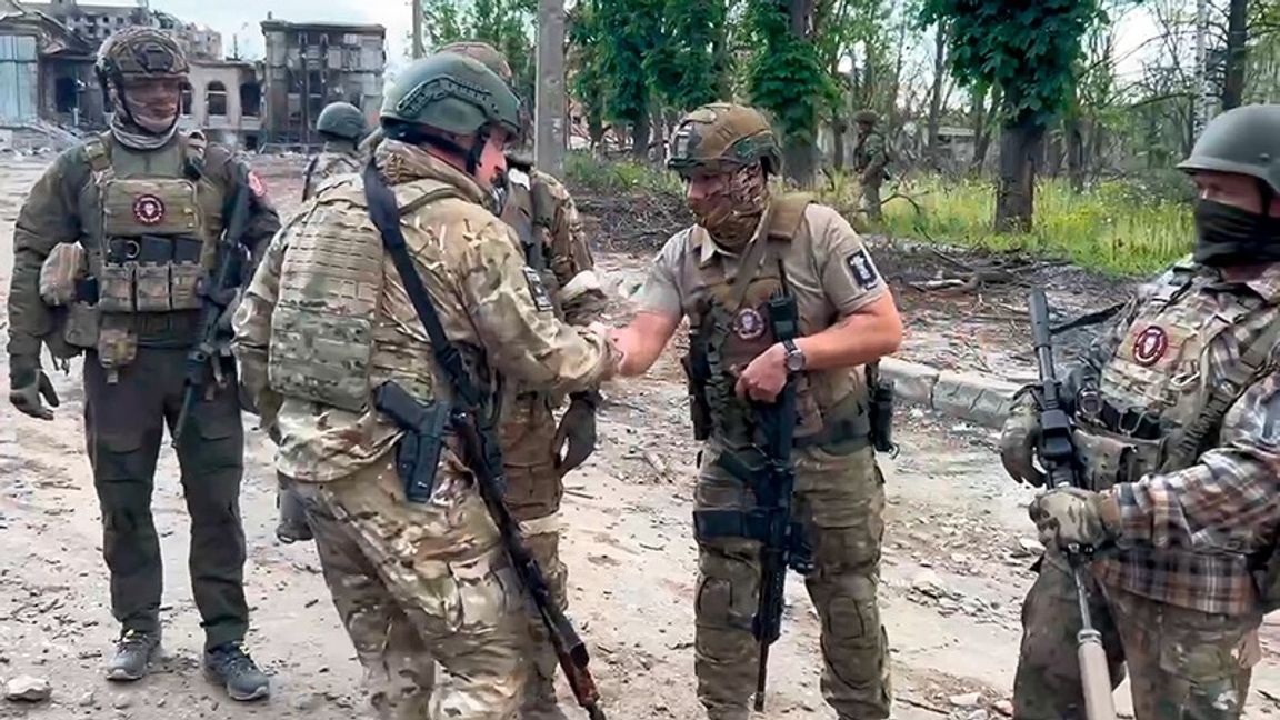 Wagnerchefen Jevgenij Prigozjin skakar hand med legosoldater igår lördag, och uppger sig intagit Bachmut. Ukrainska uppgifter motsäger detta. Foto: TT