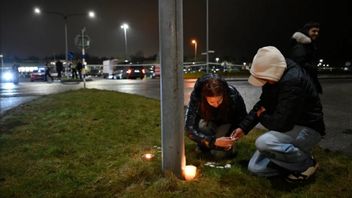 Alvin och Linn tänder ljus utanför Risbergska i Örebro skolan efter rtisdagens skolskjutning som krävde ett tiotal liv. Foto: Pontus Lundahl / TT