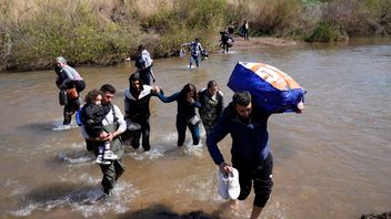 Familjer av syriska alawiter flyr över en flod. Bilden är tagen i mars i år. Hussein Malla/AP/TT