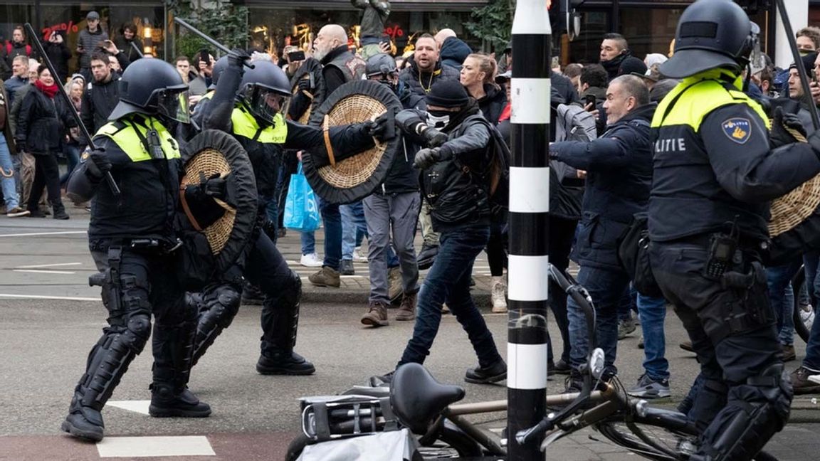 Kravallutrustad polis driver tillbaka demonstranter i Amsterdam. Foto: Peter Dejong/AP/TT