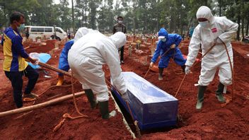 Workers in protective gear lower a coffin of a covid-19 victim to a grave for burial at the Cipenjo Cemetery in Bogor, West Java, Indonesia, Wednesday, July 14, 2021. The world’s fourth most populous country has been hit hard by an explosion of covid-19 cases that have strained hospitals on the main island of Java. Photo: Achmad Ibrahim/AP/TT