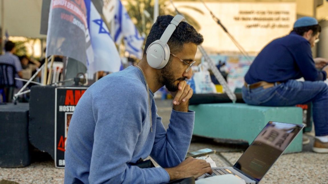 Luai Ahmed sitter och skriver på Tel Aviv Museum of Arts. Foto: Yeshaya Rosenman 