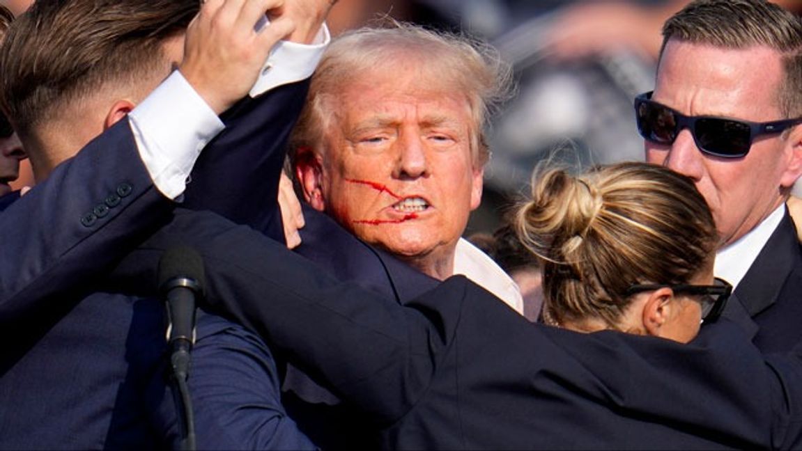 Trump hålls ner av livvakter under kampanjmötet. Foto: Gene J. Puskar/AP/TT.