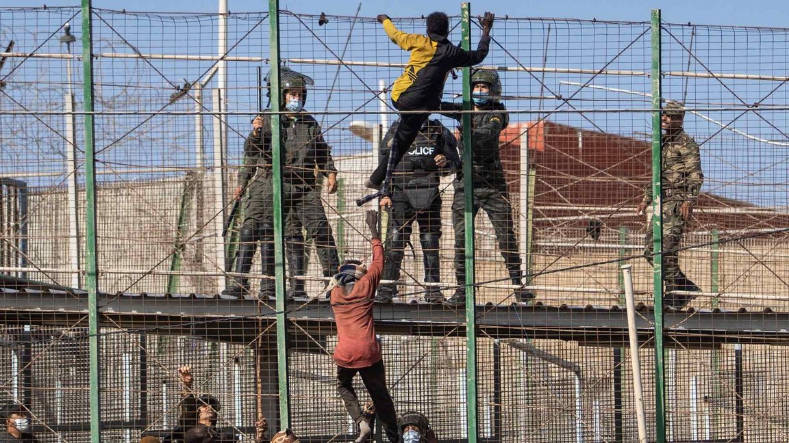 Migranter som klättrar uppför stängslet i Melilla. Foto: Javier Bernardo/AP/TT 