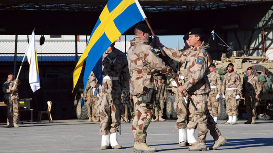 Dåvarande översten Michael Claesson, numera generallöjtnant, tar emot den svenska flaggan från överste Torbjörn Larsson i en avbytesceremoni norr om Kabul 2012. Foto: Mustafa Najafizada AP/TT