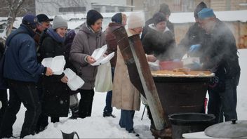 Volontären Marat Darmenov till höger delar ut gratis varm mat i Kiev under ett långvarigt strömavbrott till följd av nya ryska attacker mot Ukrainas energisystem den 7 februari 2026. Inte nog med att många ukrainare plågas av strömavbrott och avsaknad av fjärrvärme, nu kommer deras köpkraft att urholkas också. Foto: AP Photo/Sergei Grits