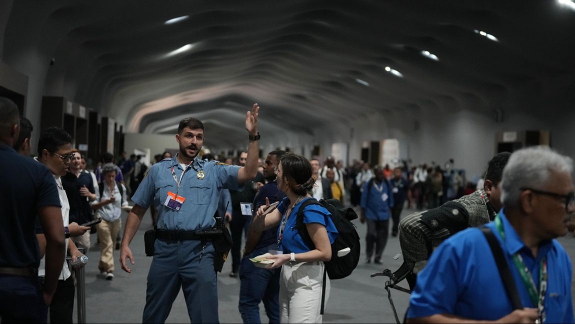 En säkerhetsvakt visar folk mot utgångarna på COP30.  Fernando Llano/AP/TT