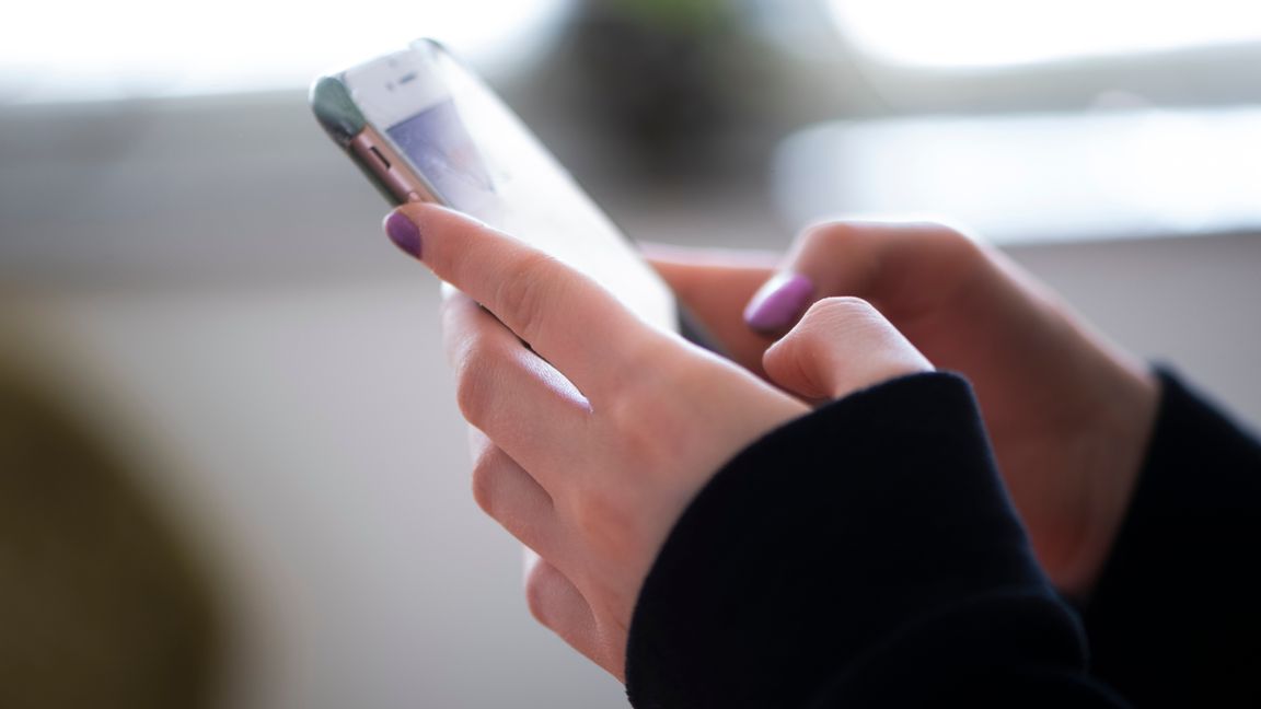 Arrangerad bild på tonåring med mobiltelefon i handen. Foto: Fredrik Sandberg/TT.