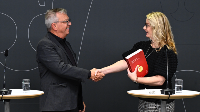 Skolminister Lotta Edholm (L) tar emot betänkandet från läroplansutredningen av särskilda utredaren Thomas Persson under en pressträff. Foto: Christine Olsson/TT