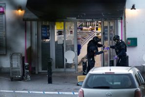 Polisen på plats i en butik i Södertälje där en granat kastades in förra sommaren. Nu har en misstänkt anstiftare häktats in sin frånvaro. Foto: Mickan Mörk/TT