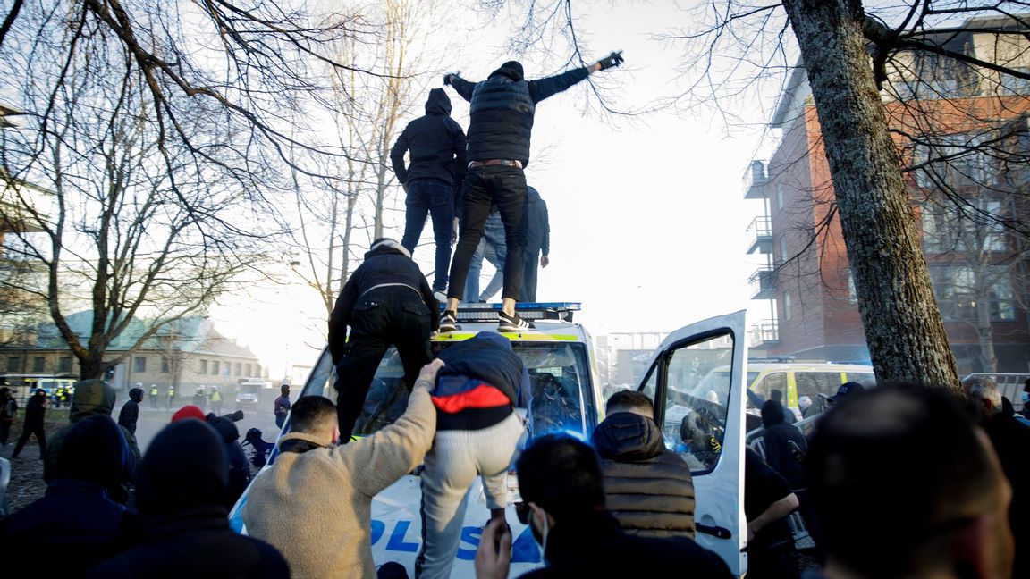 Motdemonstranter klättrar upp på en polisbuss vid Sveaparken i Örebro. Foto: Pavel Koubek/TT