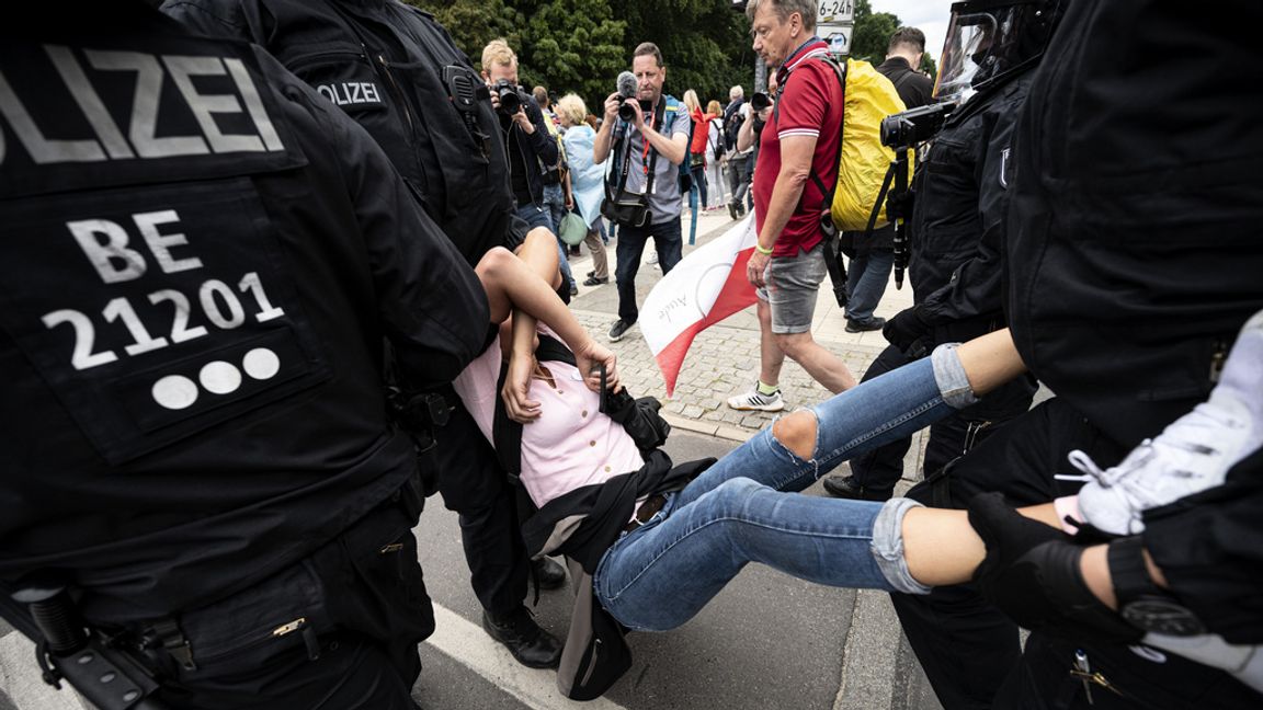 Polis griper en deltagare i den olagliga demonstrationen mot Tysklands coronaregler i Berlin på söndagen. Fabian Sommer/AP/TT