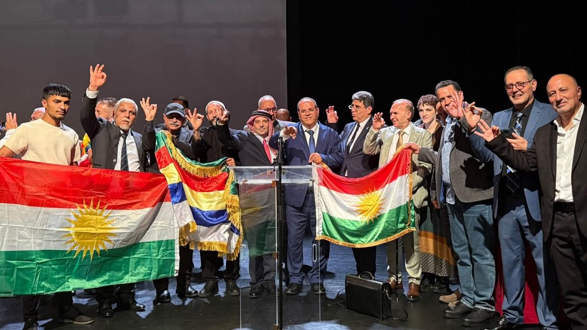 Deltagare med drusiska och kurdiska flaggor vid konferensen ”Bashan i Paris”, arrangerad av AIDPAC. Foto: Privat
