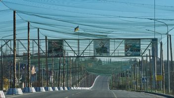 Även frontnära vägar blir vanligen del av en ”kill-zone” och för att trafik på dem inom 20 km från fronten inte ska bli automatiskt livsfarlig täcks de av anti-drönar-nät som här vid infarten till frontstaden Cherson i södra Ukraina den 2 november 2025. Foto: AP Photo/Efrem Lukatsky