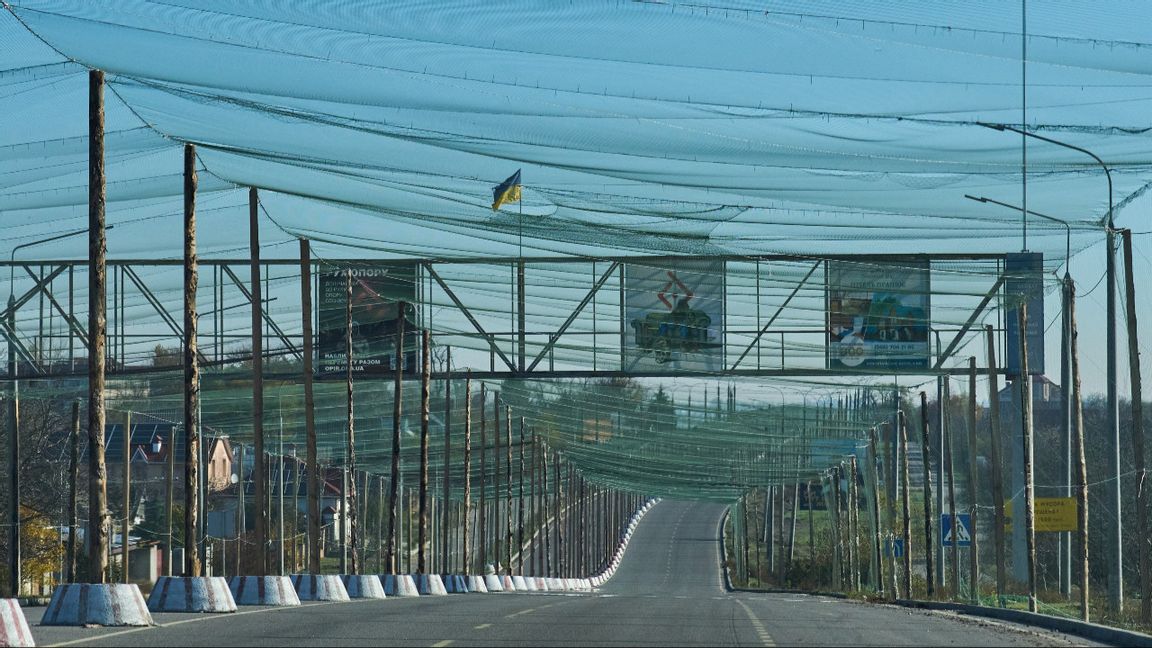Även frontnära vägar blir vanligen del av en ”kill-zone” och för att trafik på dem inom 20 km från fronten inte ska bli automatiskt livsfarlig täcks de av anti-drönar-nät som här vid infarten till frontstaden Cherson i södra Ukraina den 2 november 2025. Foto: AP Photo/Efrem Lukatsky