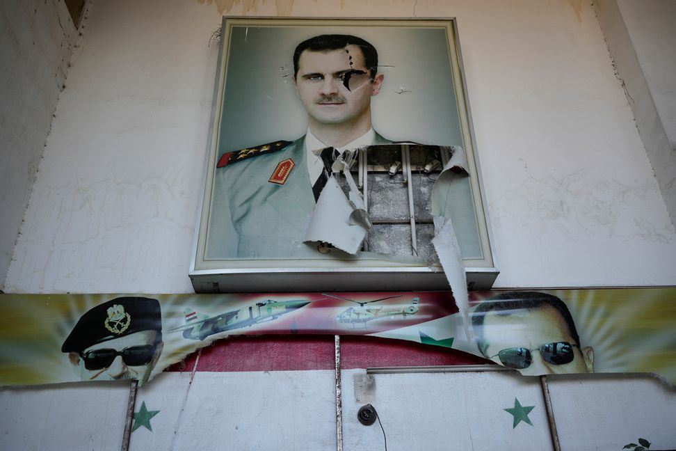 En halvt nedriven affisch på Syriens tidigare president Bashar al-Assad vid ett av Damaskus ökända fängelser. Bild tagen i lördags. Foto: Hussein Malla/AP/TT