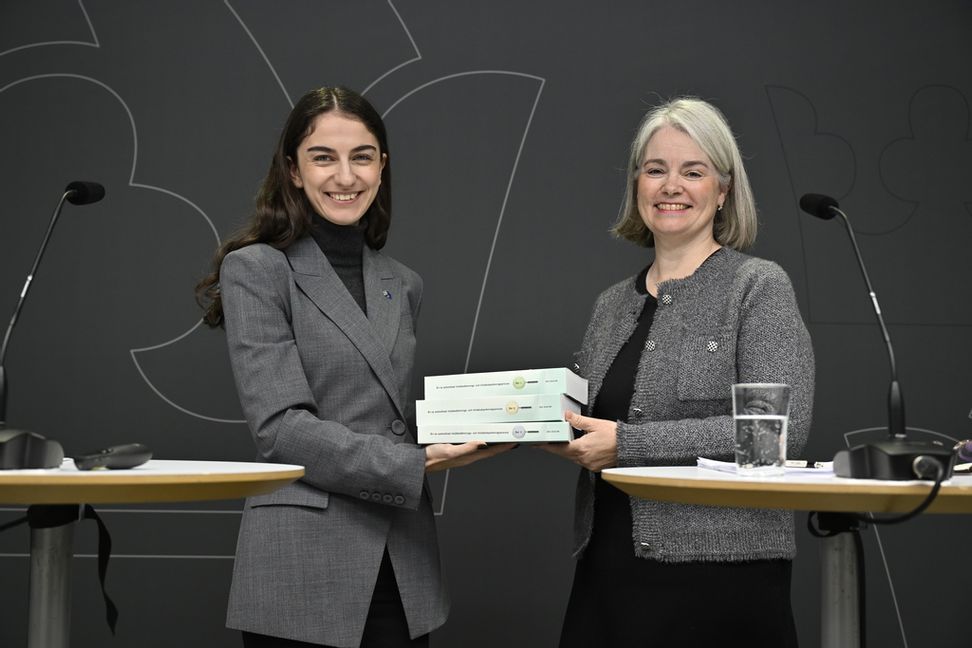 Romina Pourmokhtari (L) tar emot betänkandet från utredaren Camilla Adolfsson. Foto: Henrik Montgomery/TT