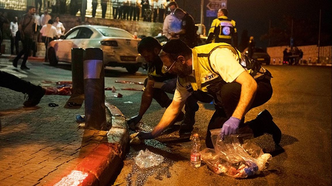 Volontärer från Zaka torkar upp blodet efter terrordådet i natt. Foto: Maya Alleruzzo/AP/TT
