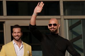 Andrew Tate vinkar vid en domstol i Rumänien i januari. Till vänster hans bror Tristan. Foto: Vadim Ghirda/AP/TT