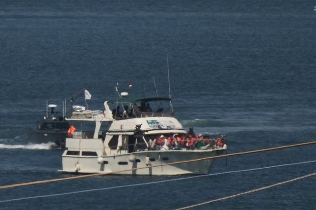 Aktivister i orangea flytvästar på en båt tillhörandes konvojen Global Sumud Flotilla som stoppats av israeliska marinen och eskorteras till israeliska hamnstaden Ashdod. Leo Correa/AP/TT