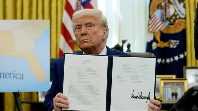 Donald Trump visar upp en undertecknad exekutiv order i Vita huset. Foto: Ben Curtis/AP/TT