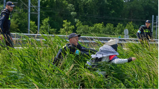 Holländsk polis grep på måndagen klimataktivister som blockerade motorvägen A44 nära Lisse inför NATO-toppmötet i Haag. Foto: Peter Dejong/AP/TT