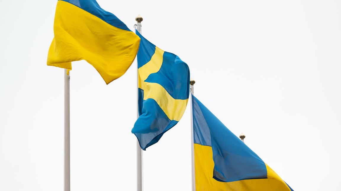 Ukrainas flagga vajar i vinden bredvid dens svenska flaggan på årsdagen av Rysslands invasion av Ukraina. Foto: Henrik Montgomery / TT