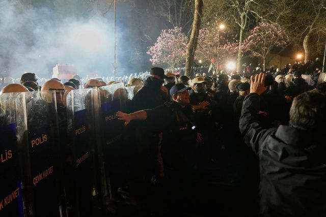 En polis försöker mana till lugn vid demonstrationerna i Istanbul. Bild från 26 mars. Foto: Khalil Hamra/AP/TT