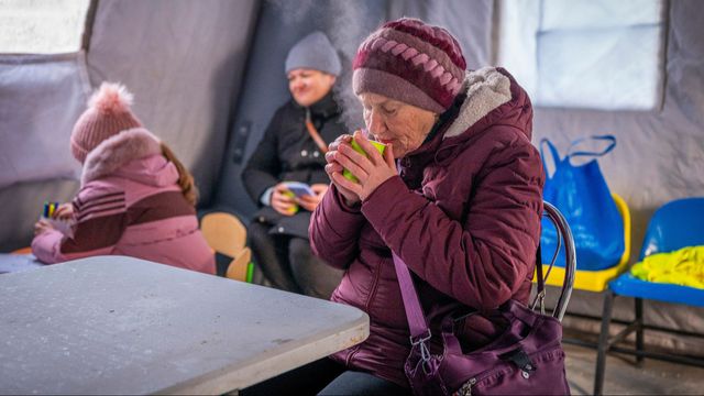 En kvinna i Boryspil, öster om Kiev, får en välbehövlig kopp te den 14 januari på en ” opåverkbarhetspunkt” som satts upp runt om i Ukraina för att folk ska kunna värma sig och ladda bland annat sin mobiltelefon under de extra långvariga strömavbrott som följt på Rysslands mot ukrainsk energiinfrastruktur. Foto: AP Photo/Dan Bashakov
