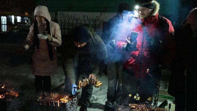 Kievbor grillar utomhus i vinterkylan utomhus den 18 januari 2026 då deras lägenheter ändå saknar fjärrvärme och el efter upprepade ryska attacker mot den ukrainska huvudstadens infrastruktur. Foto: AP Photo/Danylo Antoniuk