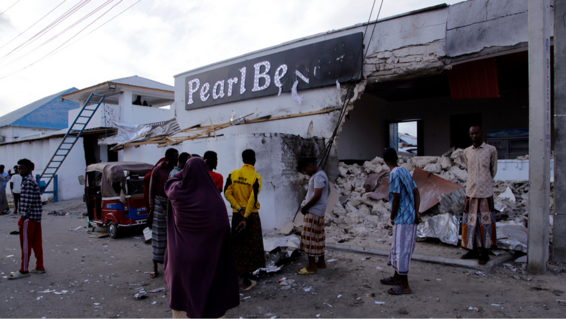 Människor betraktar förstörelsen utanför hotellet Pearl Beach i Somalias huvudstad Mogadishu, som attackerades av terrorgruppen al-Shabab på fredagen. Foto: Farah Abdi Warsameh/AP/TT