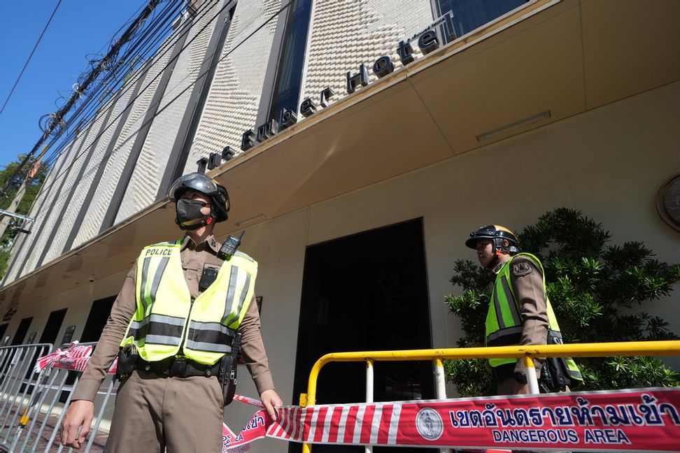 Polisen vaktar vid hotellet efter nattens brand. Foto: Sakchai Lalit/AP/TT