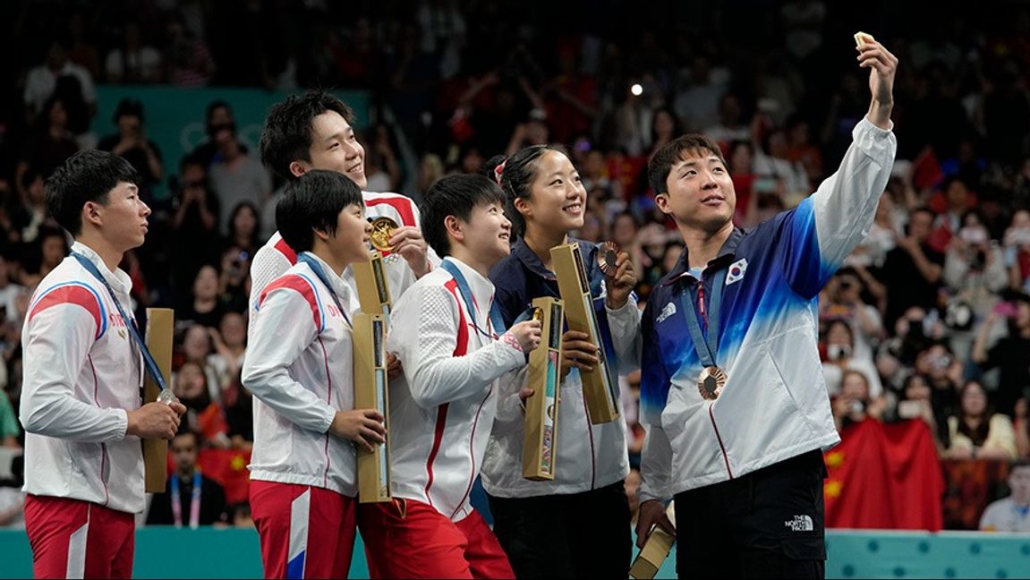 Ri Jong Sik och Kim Kum Yong (längst till vänster) deltog i en selfie med kinesiska och sydkoreanska tävlande under OS i Paris. Foto: Petros Giannakouris/AP/TT