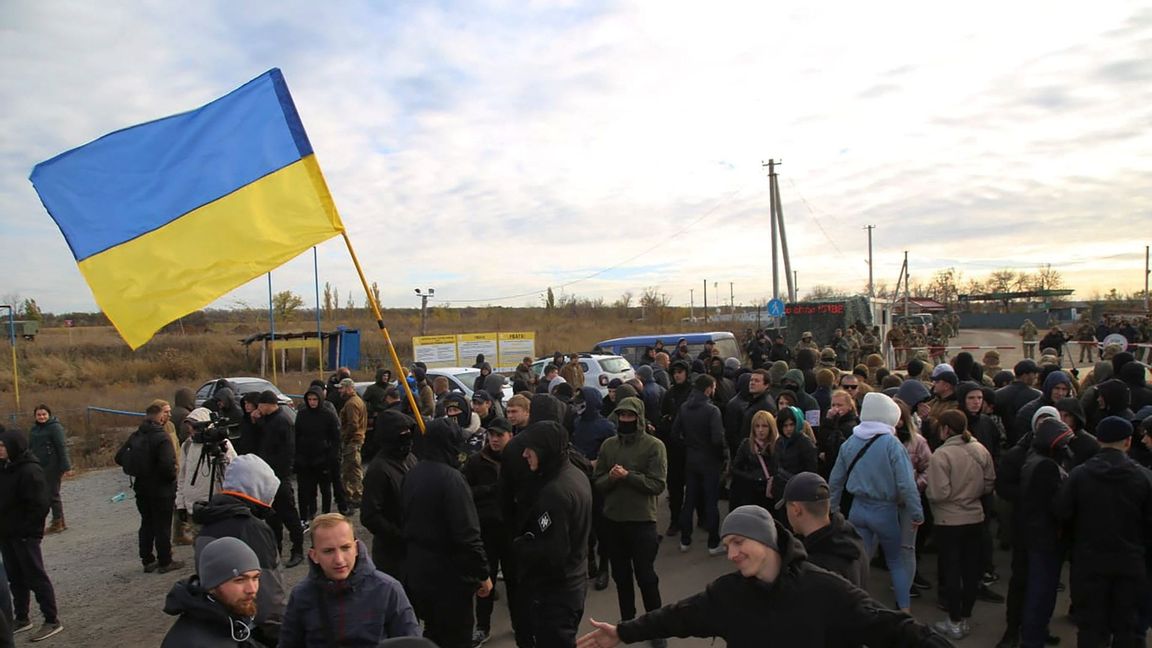 Ukrainska arméveteraner och volontärer viftar med Ukrainas flagga. Foto: Bohdan Kutepov/AP/TT