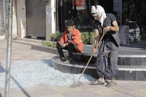 Invånare i Jemens huvudstad Sanaa städar krossat glas efter de amerikanska attackerna. Osama Abd al-Rahman/AP/TT