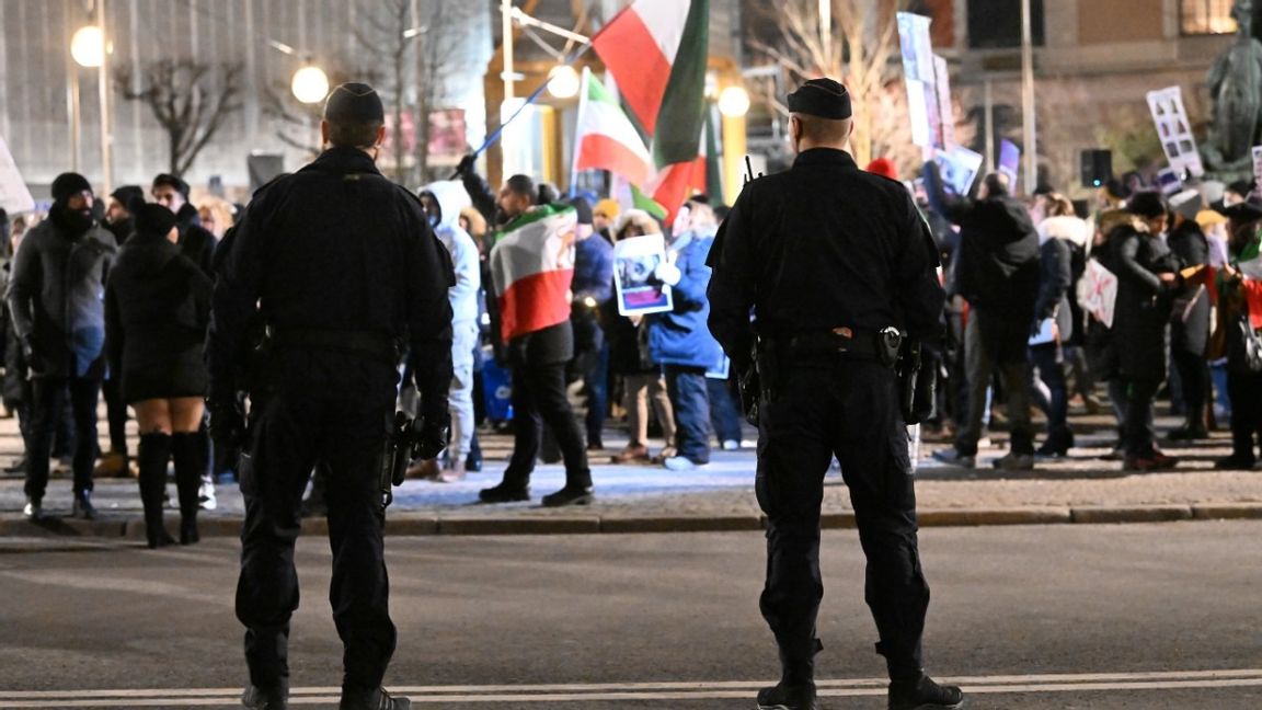 Poliser står uppställda vid Gustav Adolfs torg i Stockholm i samband med en demonstration mot regimen i Iran på tisdagskvällen. Foto: Fredrik Sandberg/TT