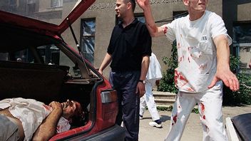 Bild från det belägrade Sarajevo 1995. Mannen i bakluckan dödförklarades kort efter att bilden togs. Bild: AP Photo/Enric Marti