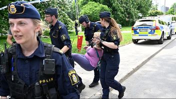 Klimataktivister förs bort av polis efter en aktion för Återställ Våtmarker utanför Finlands ambassad. Återställ våtmarker är en av de grupper som medlemmarna i det hemliga nätverket engagerar sig i. Foto: Jessica Gow / TT