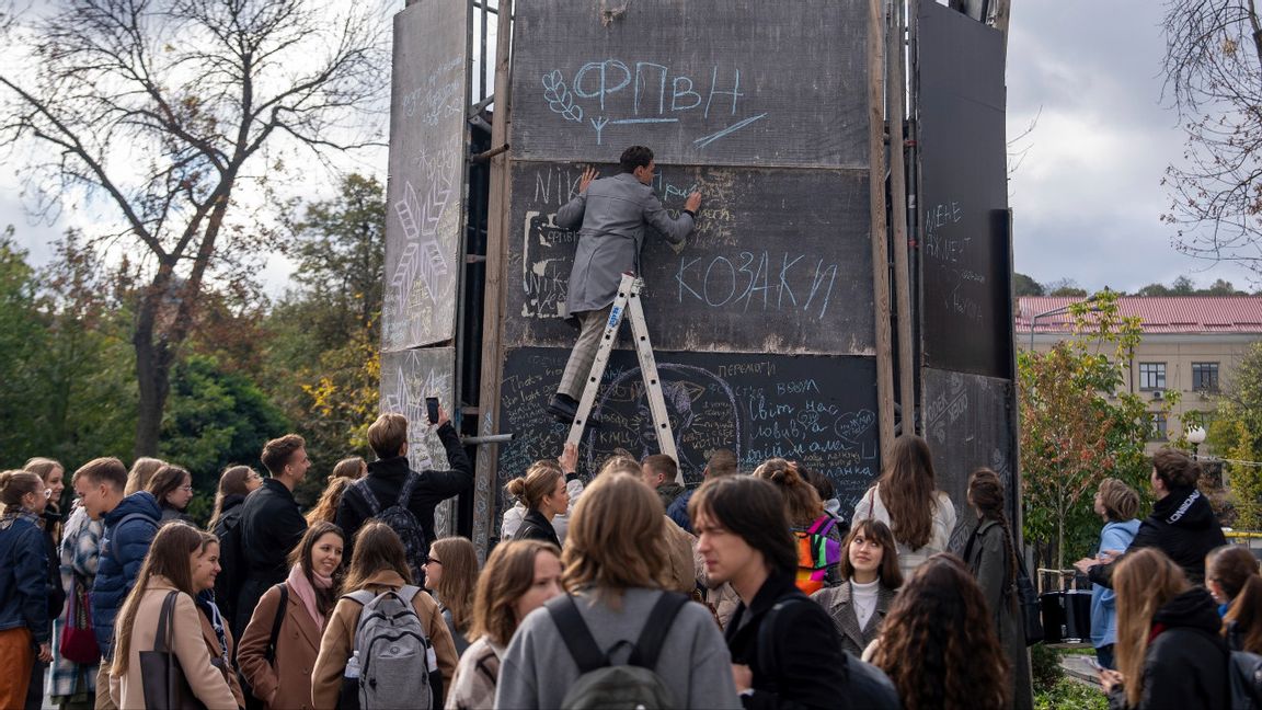 Studenter på den prestigefulla Kiev-Mohyla-akademin målar och skriver traditionsenligt sina önskningar för framtiden på ett monument på universitetets födelsedag den 15 oktober 2024. Foto: AP Photo/Alex Babenko