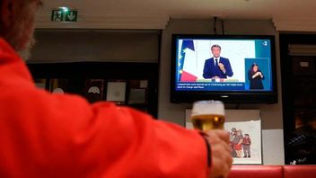 En man ser Macrons tv-tal på en bar i Baoynne i sydvästra Frankrike. Foto: Bob Edme/AP/TT