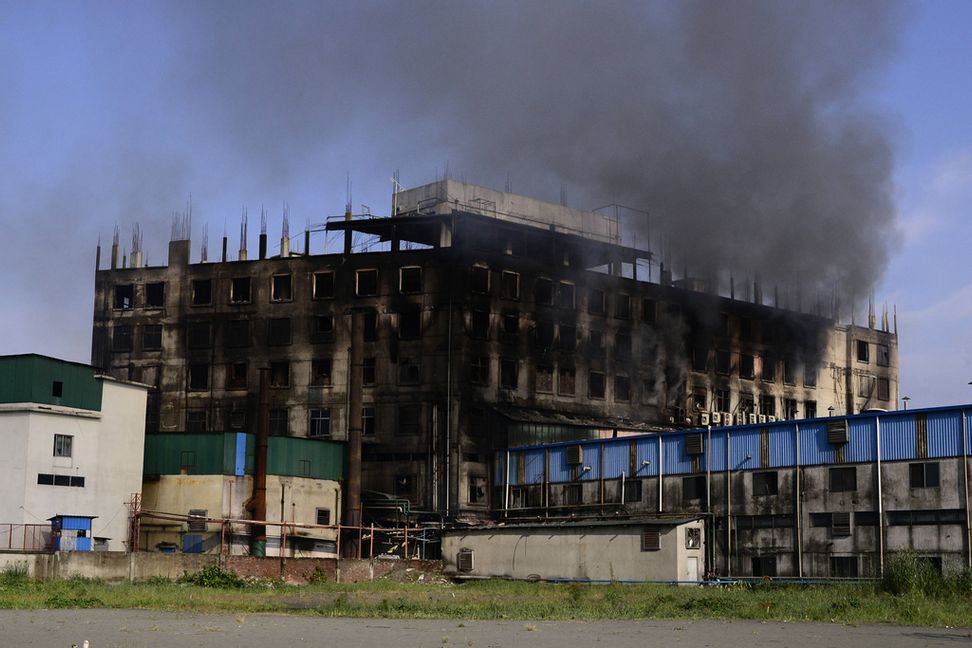 Rök stiger från den fabrik där en dödlig brand bröt ut utanför Dhaka, Bangladesh på fredagen. Mahmud Hossain Opu/AP/TT.